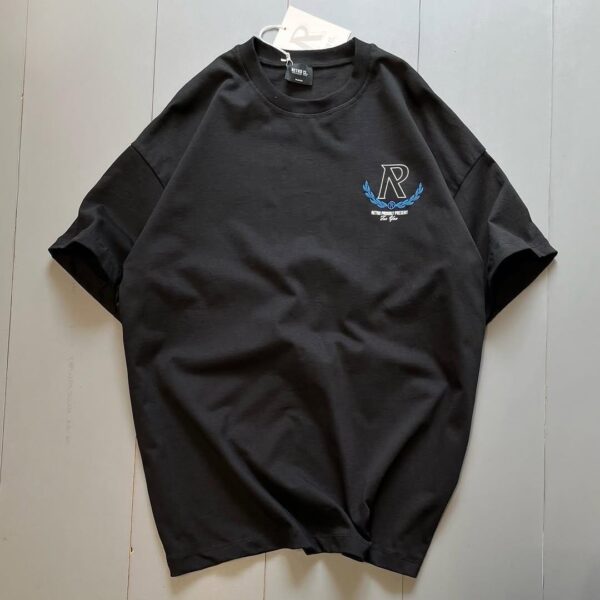 **Alt Text:** Oversized drop shoulder t-shirt with bold front and back "R" print, made from soft PC Jersey fabric. Available in black, brown, and grey, in sizes medium, large, and extra large.